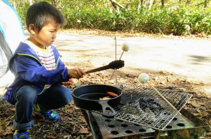 野外調理をする男の子