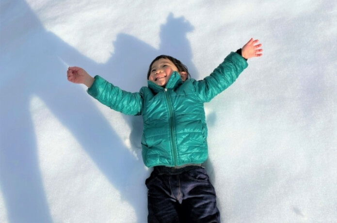 雪の上に寝転がる子ども